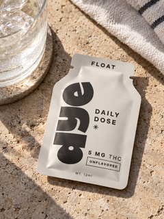 FLOAT unflavored 5mg THC packet beside a glass of water